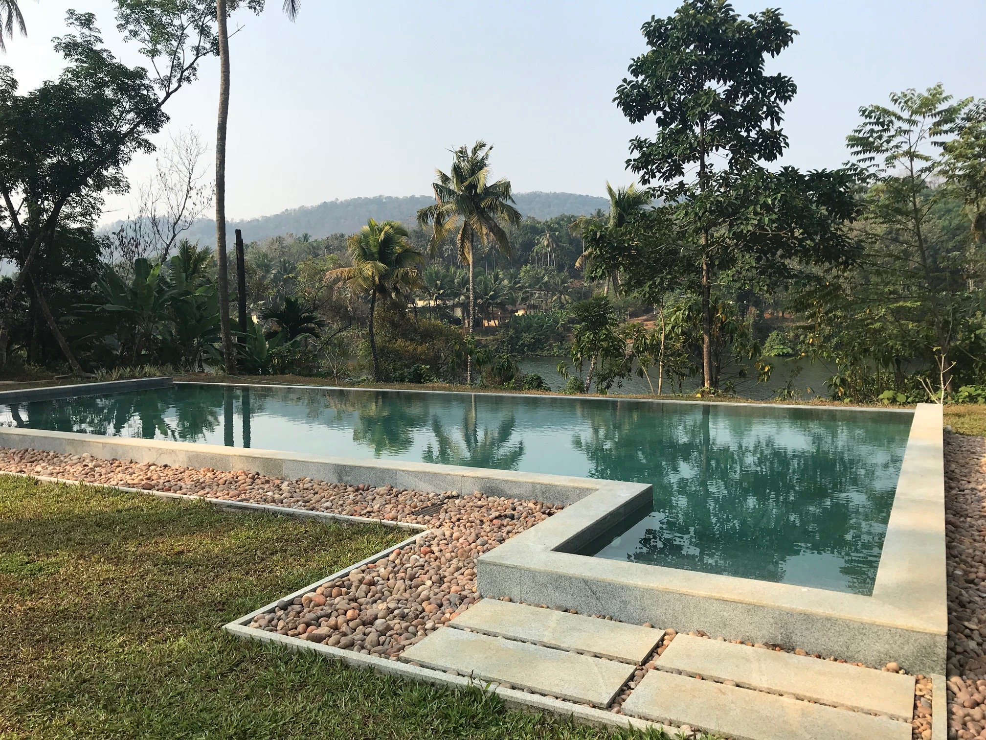 The pool at Windermere River House with views of the Periyar River