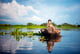 cambodian-boy-traveling-by-boat-in-floating-villag-2022-12-16-00-25-44-utc-1
